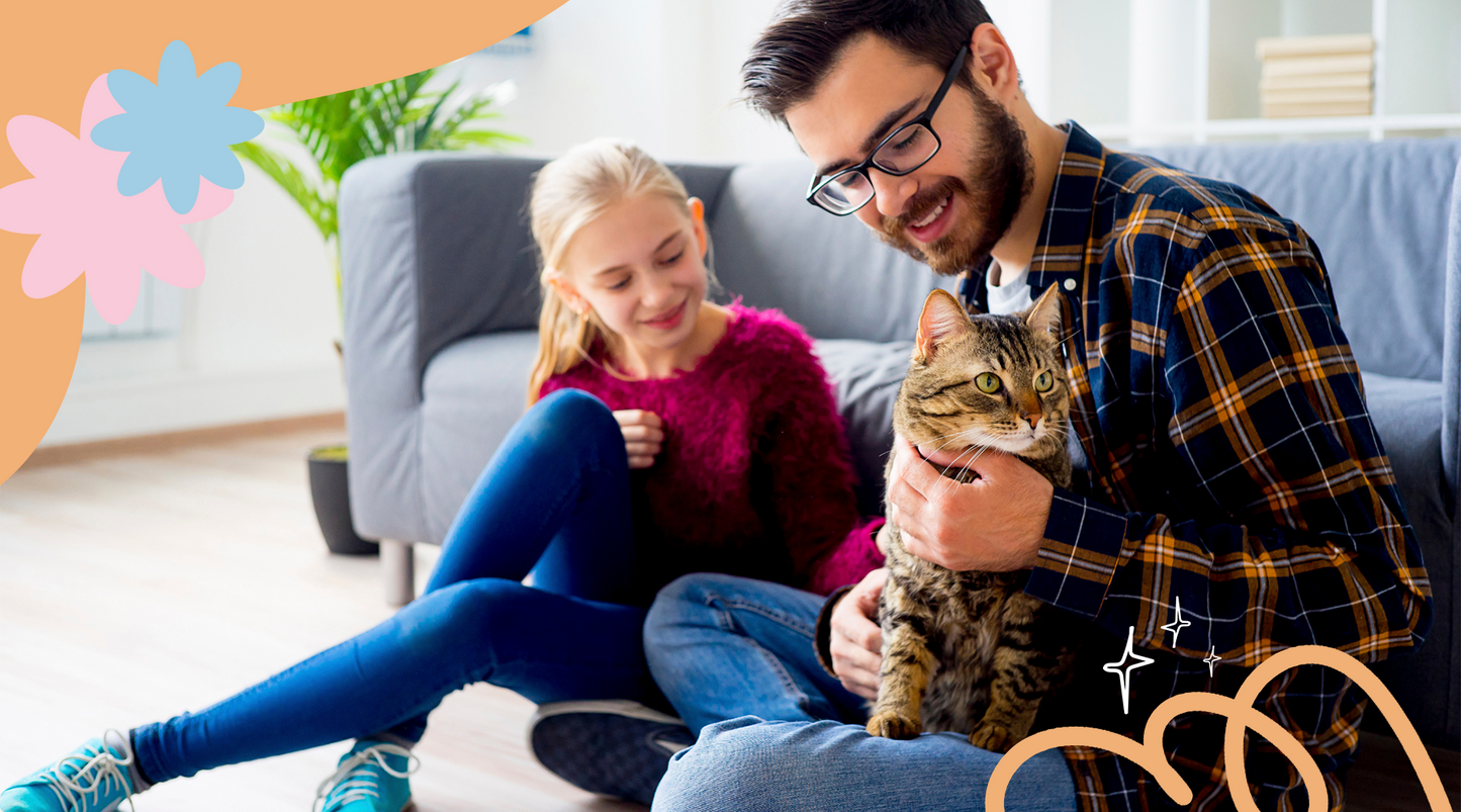 Joyful dad and daughter smiling and holding their beloved cat.